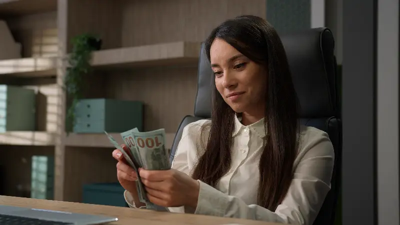 Mujer contando billetes como parte de un plan de ahorro para el retiro